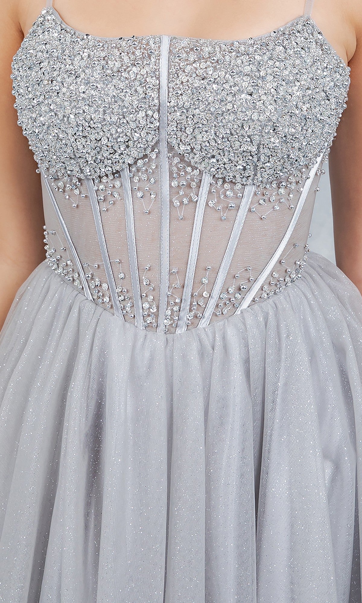 Close-up of the Long Prom Dress: Cinderella Couture 8459J—a silver glitter gown featuring a beaded corset bodice, sheer paneling, and a flowing shimmery A-line tulle skirt.